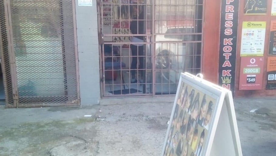 Entrance of G&L Hair Salon and Nails, Cape Town, Western Cape, ZA, showcasing a poster display of hairstyles.