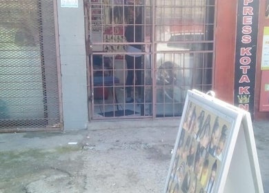 Entrance of G&L Hair Salon and Nails, Cape Town, Western Cape, ZA, showcasing a poster display of hairstyles.