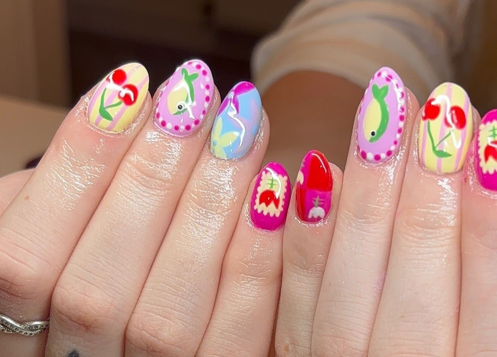Vibrant nail designs at Gels by Elise, Forres, GB, showcasing colorful, creative art on both hands.