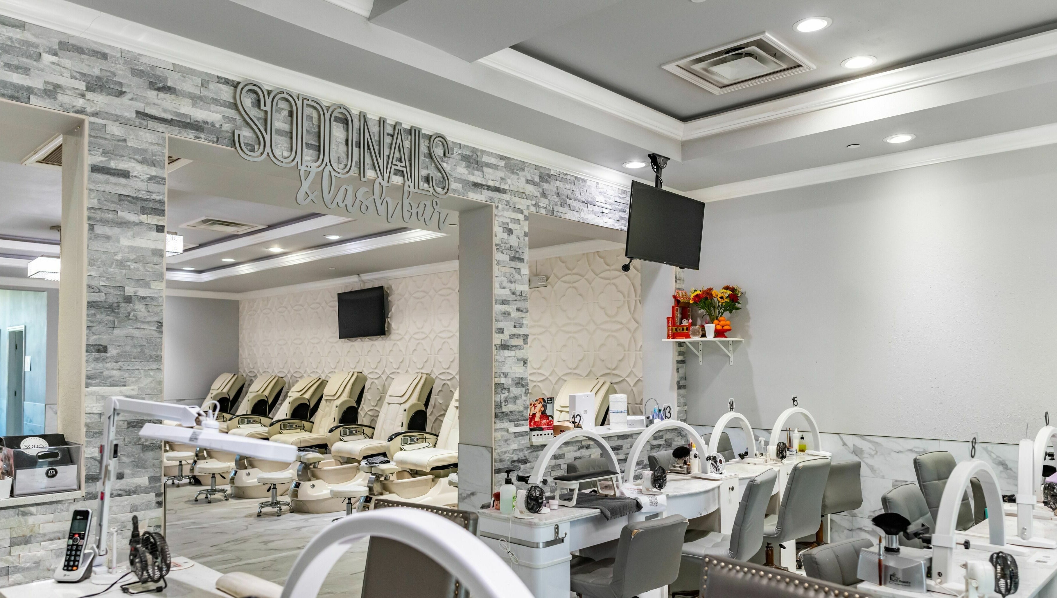 Interior view of SODO Nails & Lash Bar, Orlando, Florida, US, featuring modern decor and luxurious seating.