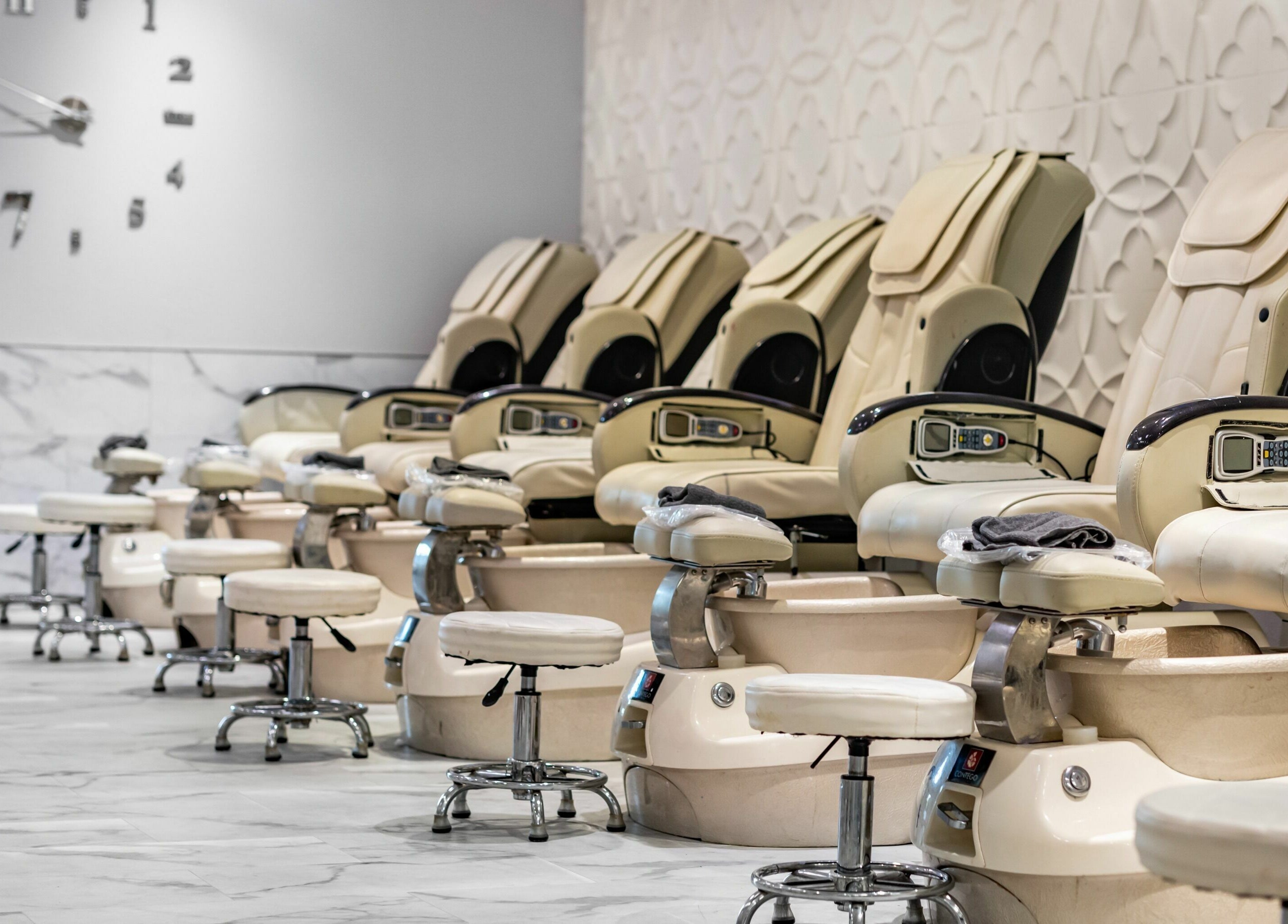 Pedicure chairs at SODO Nails & Lash Bar in Orlando, Florida, US, with a stylish, marble-finished interior.
