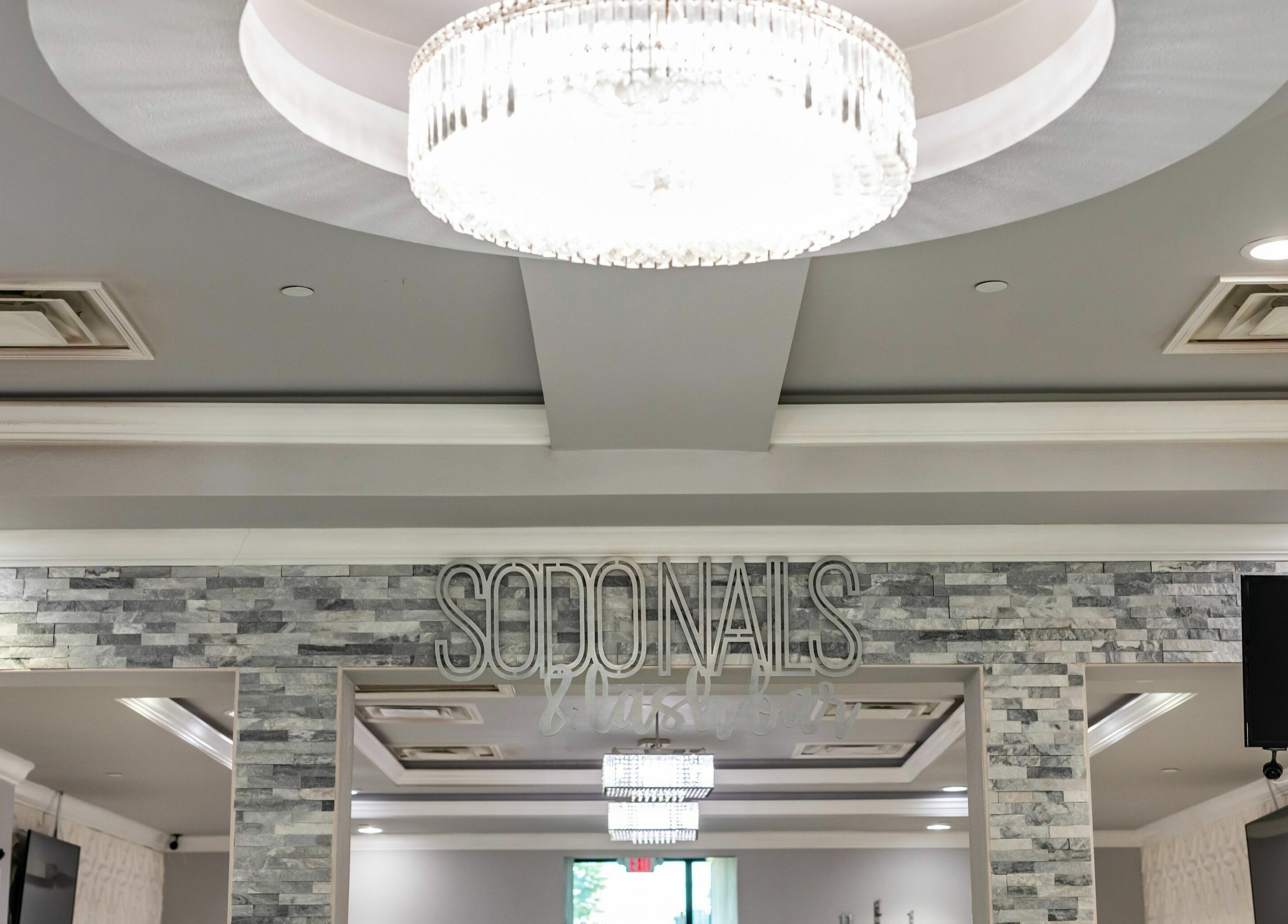 Elegant interior of SODO Nails & Lash Bar in Orlando, Florida, US with glamorous lighting and modern decor.