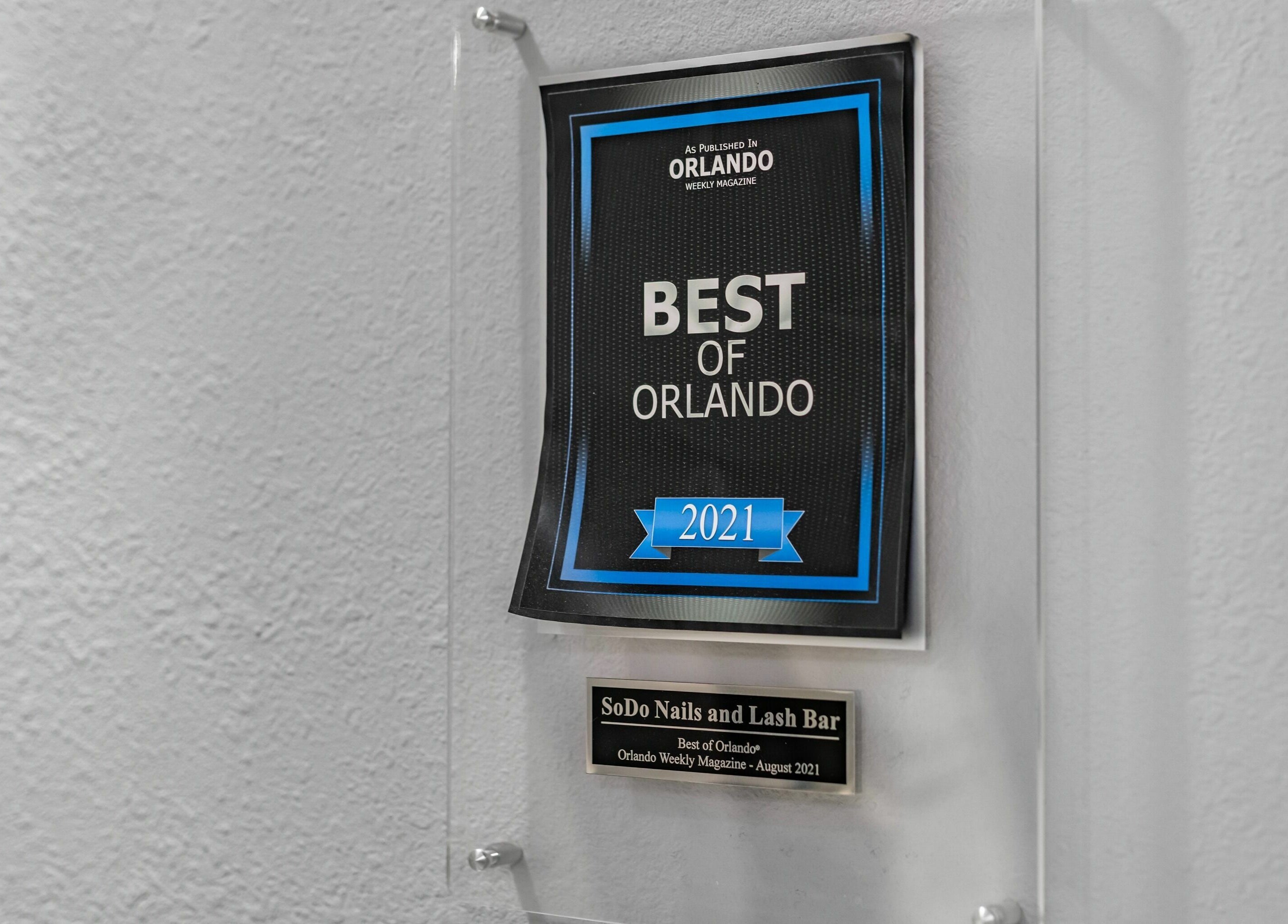 Best of Orlando 2021 plaque awarded to SODO Nails & Lash Bar, Orlando, Florida, US, on a textured wall.