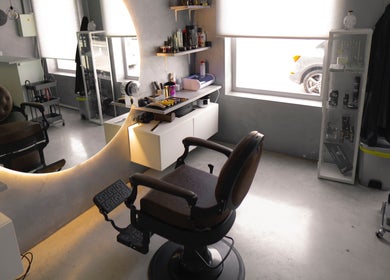 Interior moderno de M.A.S barbershop en Alguazas, Región De Murcia, ES, con sillas y espejo iluminado.