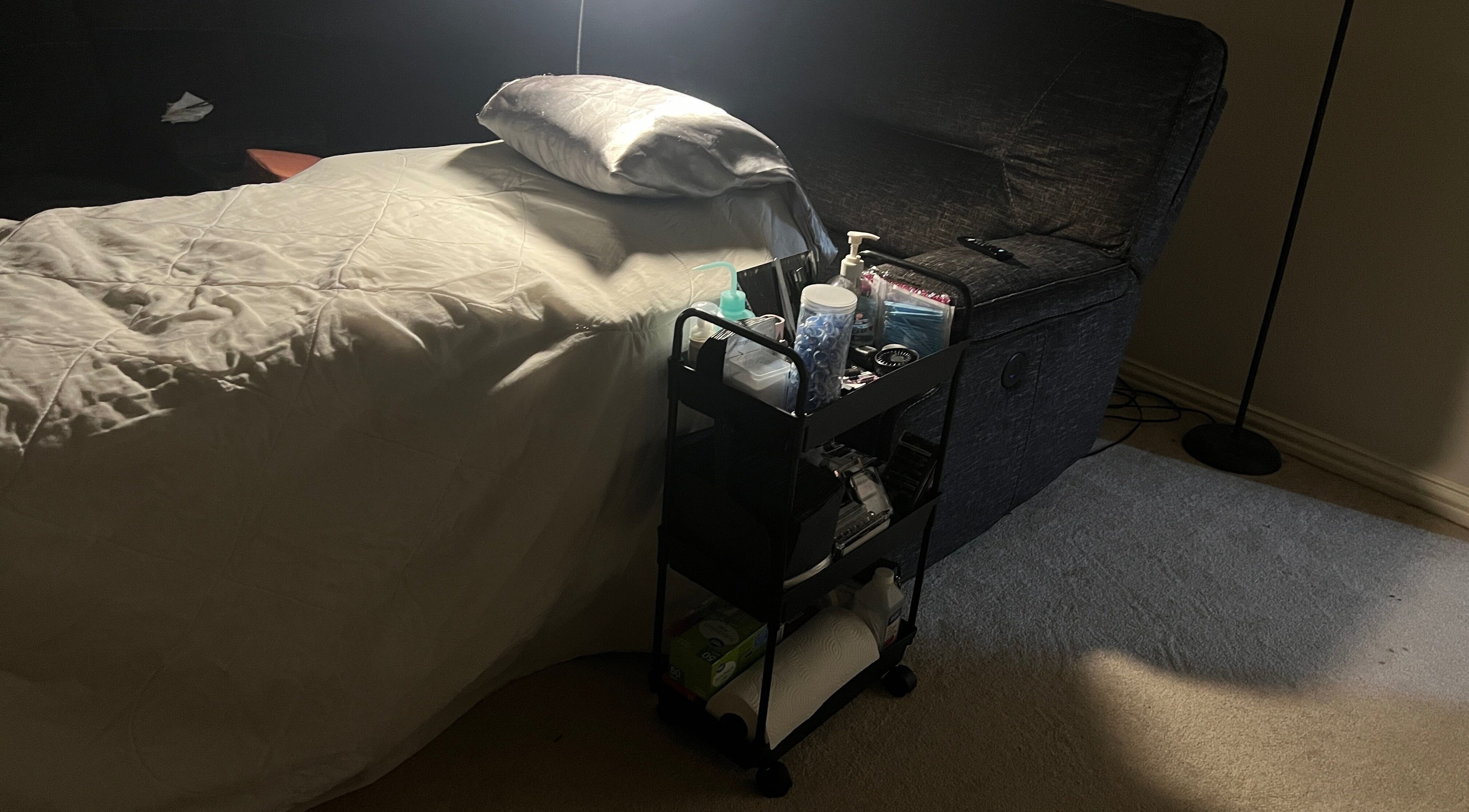 Comfortable beauty treatment setup at The Lash Rabbit, Desoto, Texas, US with bed and supplies cart.