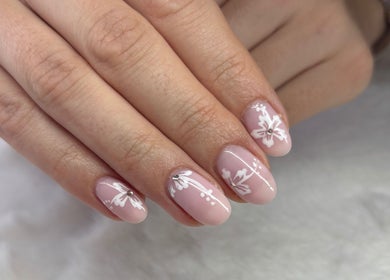 Elegant floral nail art at Vee Oli Nails, Johannesburg, Gauteng, ZA. Delicate white designs on pink nails.