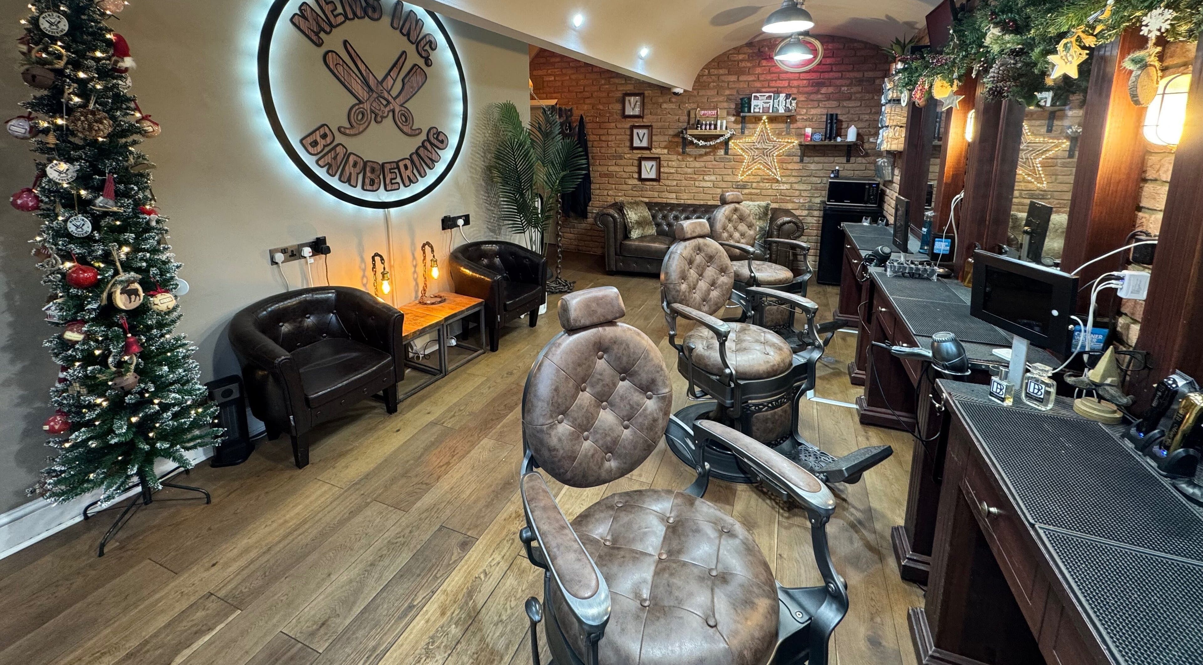 Interior of Mens Inc Barbering in Ipswich, England, GB, featuring leather chairs and festive decor.