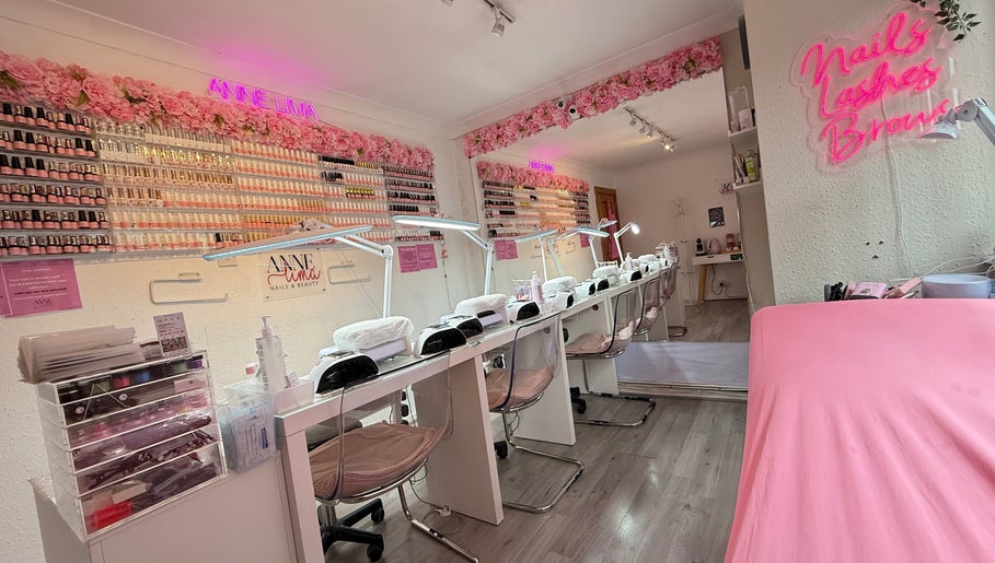 Anne Lima Nails & Beauty, Dublin 2, showcases a modern, pink-themed nail salon with seating and polish displays.