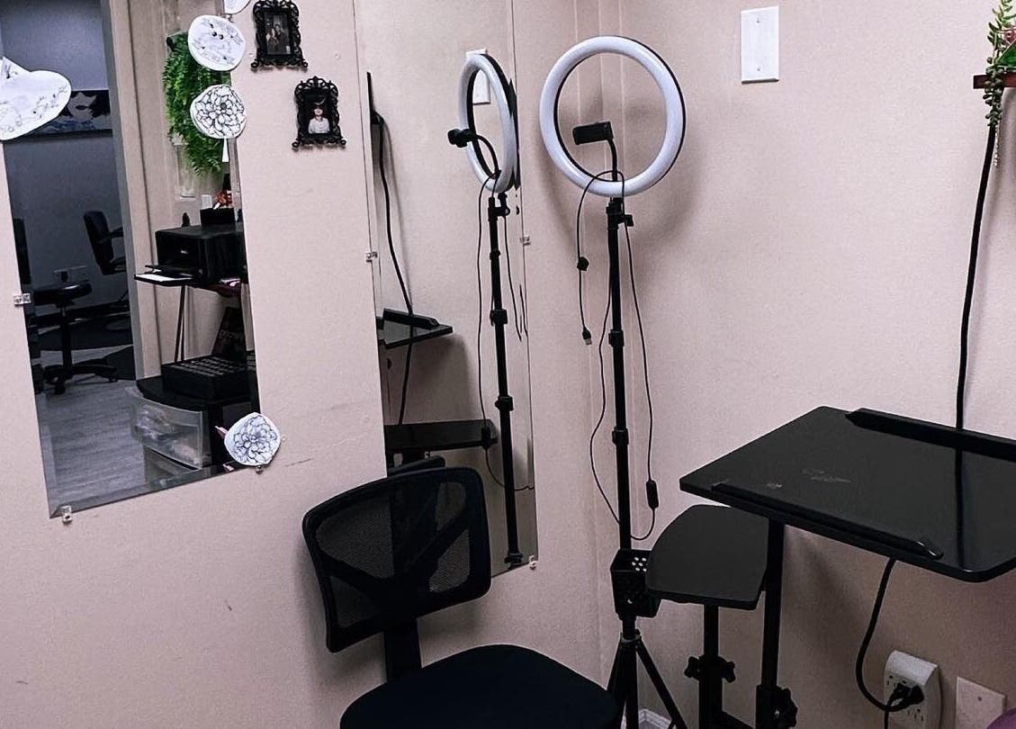 Tattoo station at K. Tabone Tattoo, Rochester, New York, US featuring chair, ring light, and mirror.