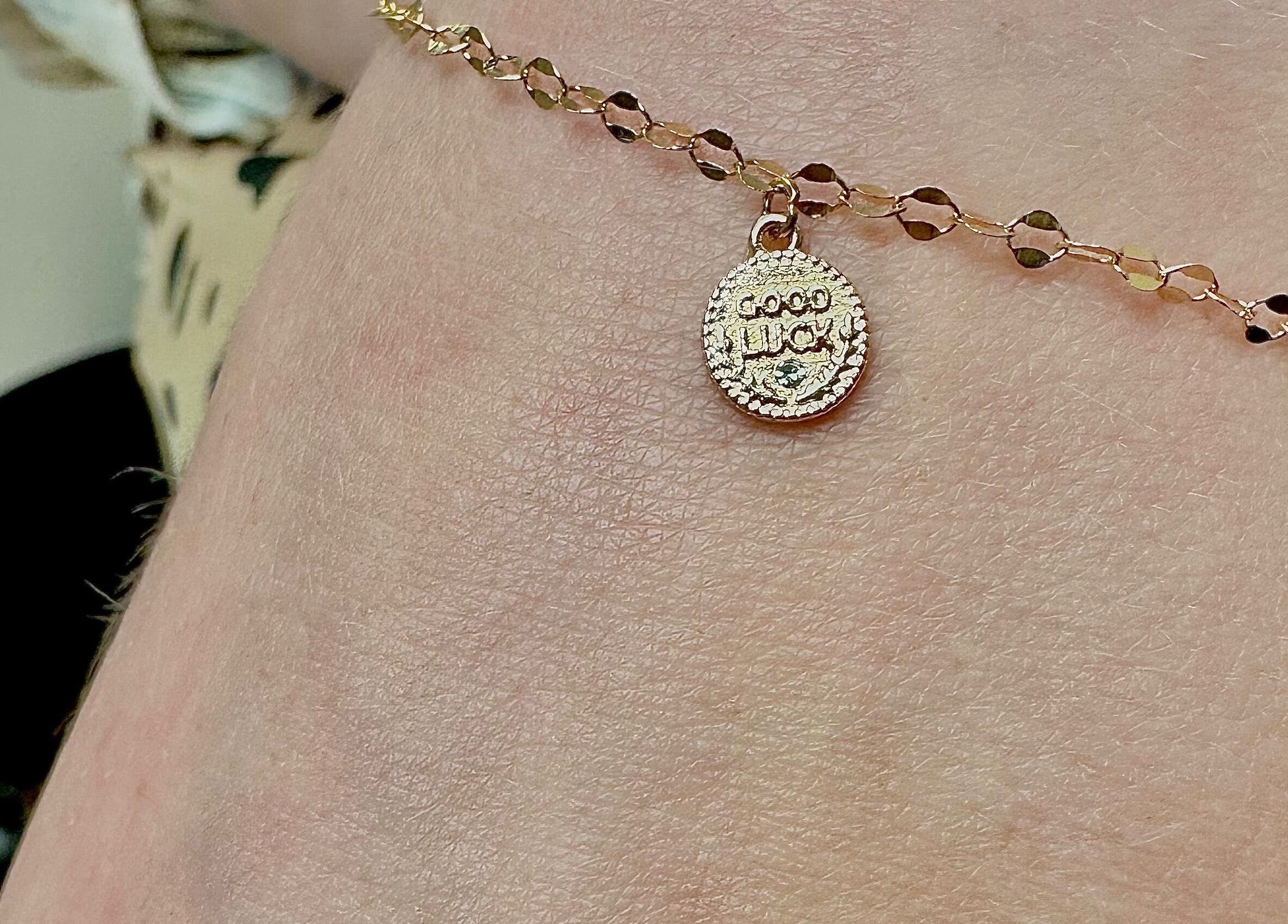 Gold 'Good Luck' charm bracelet showcased at K. Tabone Tattoo, Rochester, New York, US.