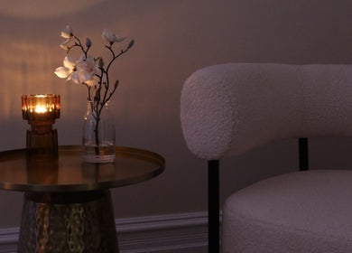 Warm candlelit atmosphere at The Head Spa Perth, South Perth, Western Australia, AU with a chic chair and table.