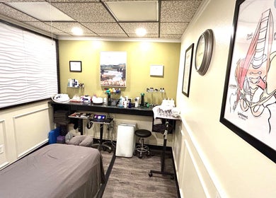 Calming treatment room at Revive Integrative Wellness | Abilene, Texas, US, with massage table and artwork.
