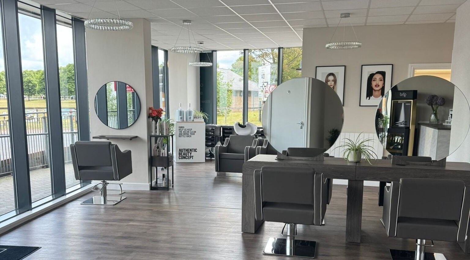 Spacious interior of Hair Artistry Newmarket salon, Newmarket, England, GB, with stylish chairs and large mirrors.