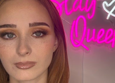 Elegant woman with glowing makeup at Glo With The Flo, Larbert, Scotland, GB. Eye-catching neon sign behind.