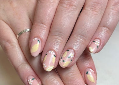 Lemon-themed nail art at Beauty By Eloise, Godshill, England, GB. Delicate floral designs enhance the nails.