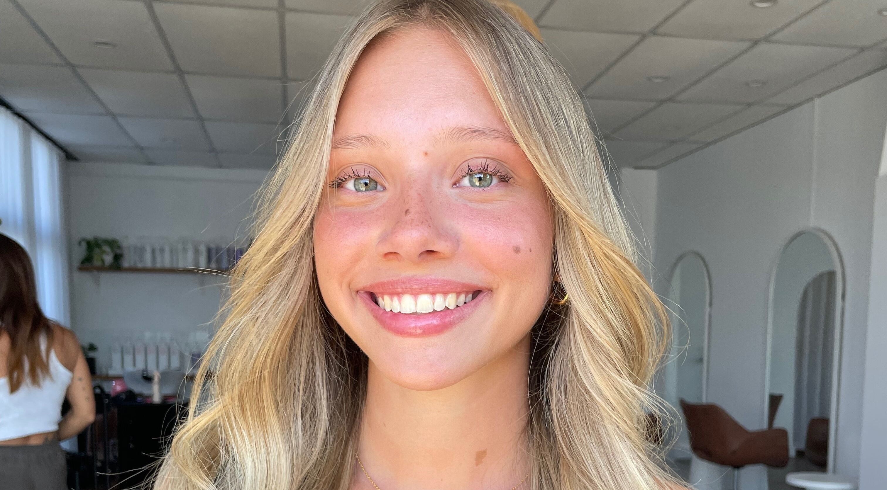 Smiling woman with sunlit blonde hair at Hair By Brooklyn, Miami, Queensland, AU.