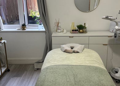 A tranquil treatment room at Reenas Touch, London, England, GB, featuring a massage bed and calming decor.