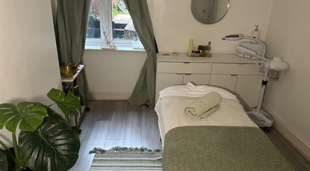 Cozy treatment room at Reena’s Touch in London, England, GB with a soft bed, plants, and ambient lighting.