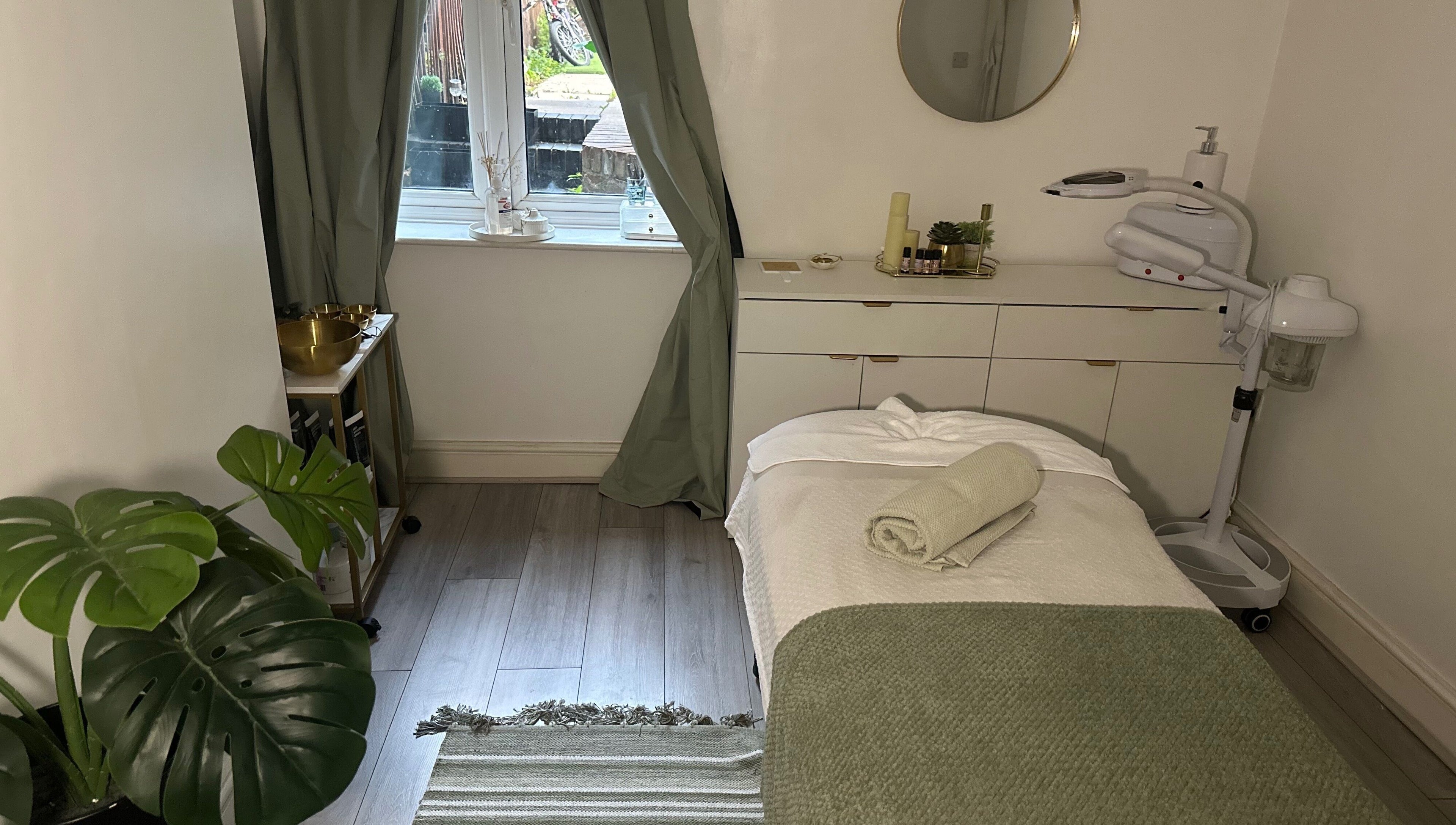 Relaxing massage room at Reena’s Touch, London, England, GB, with a cozy bed and serene decor.