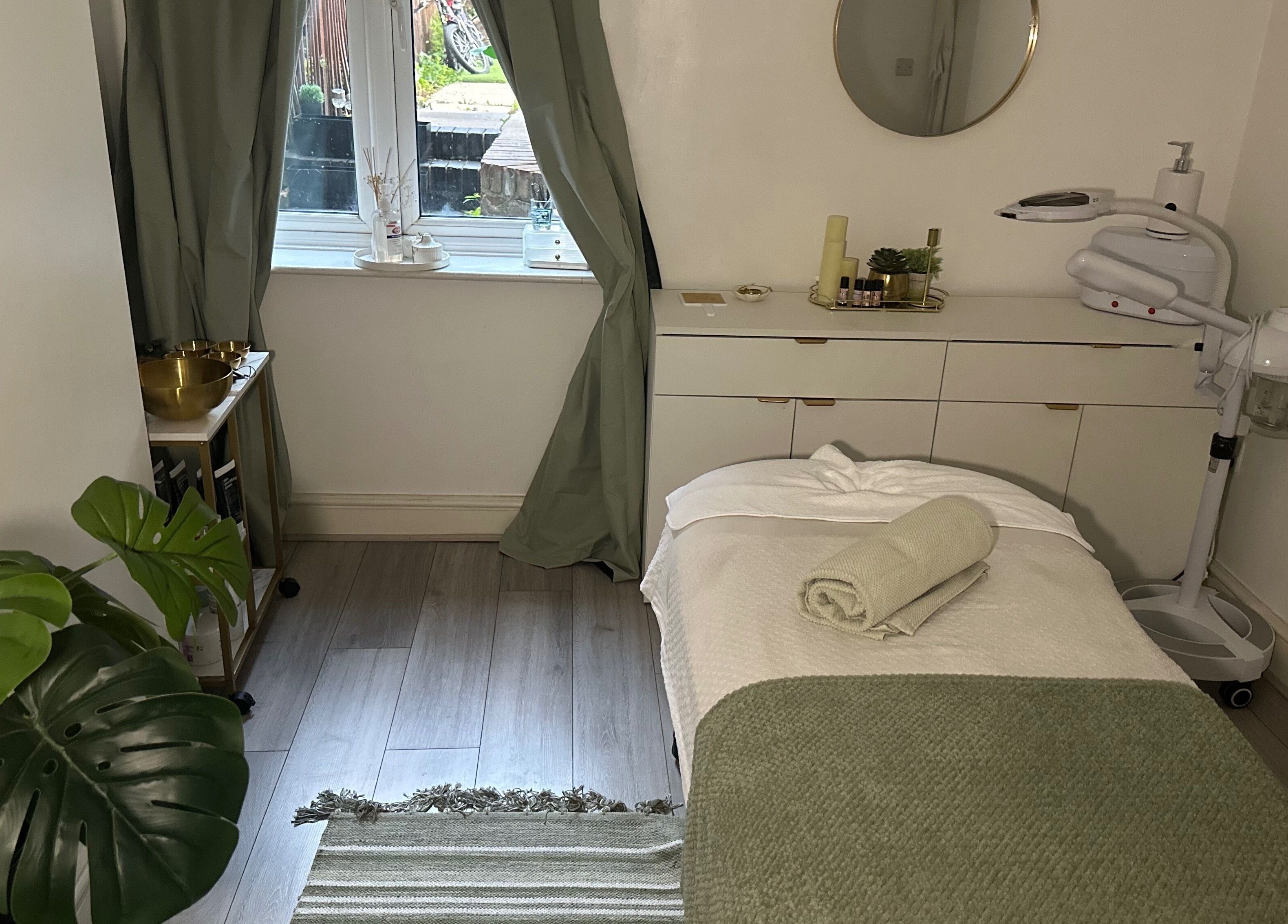 Relaxing massage room at Reena’s Touch, London, England, GB, with a cozy bed and serene decor.