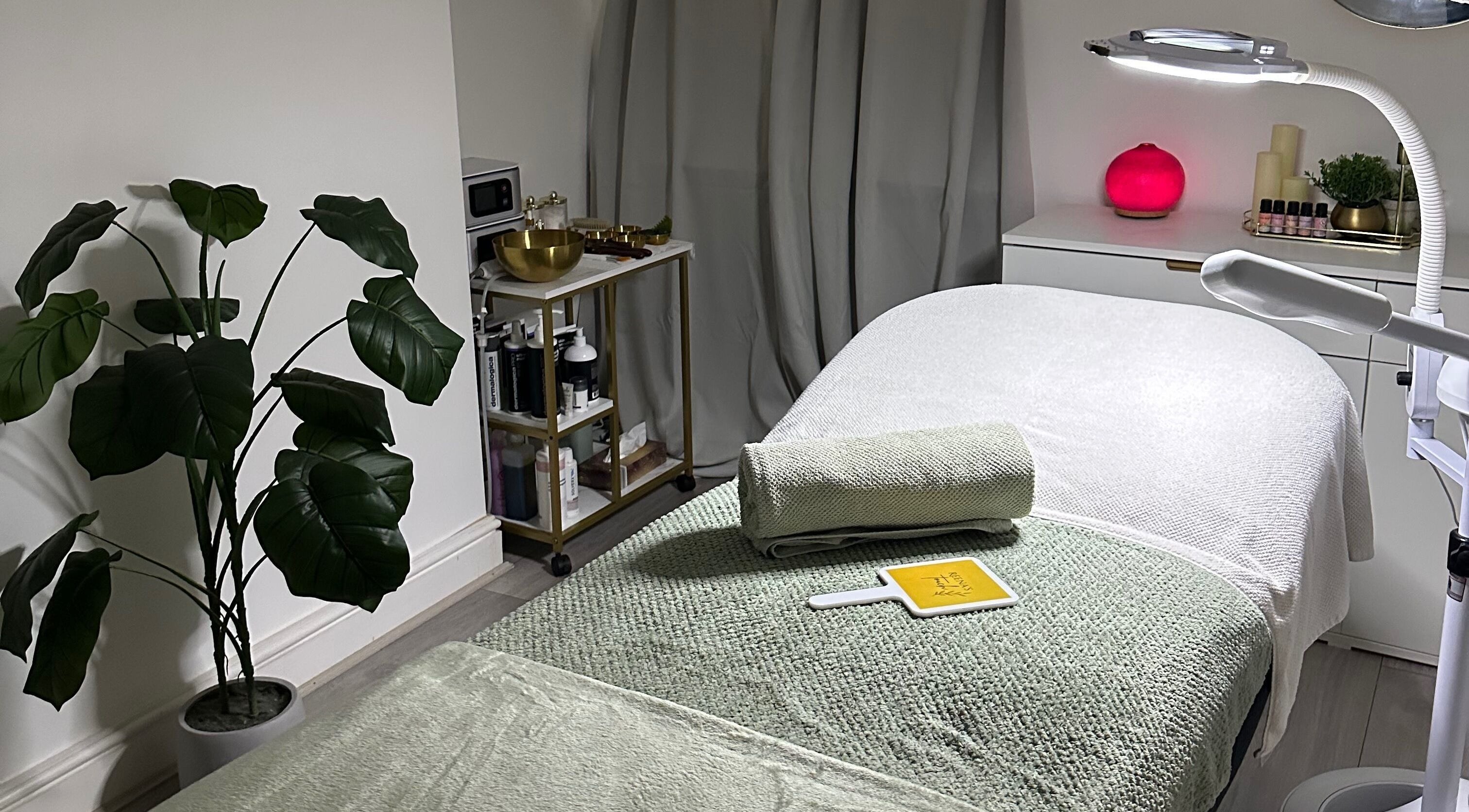 Relaxing treatment room at Reena’s Touch, London, England, GB with a cozy bed and calming decor.