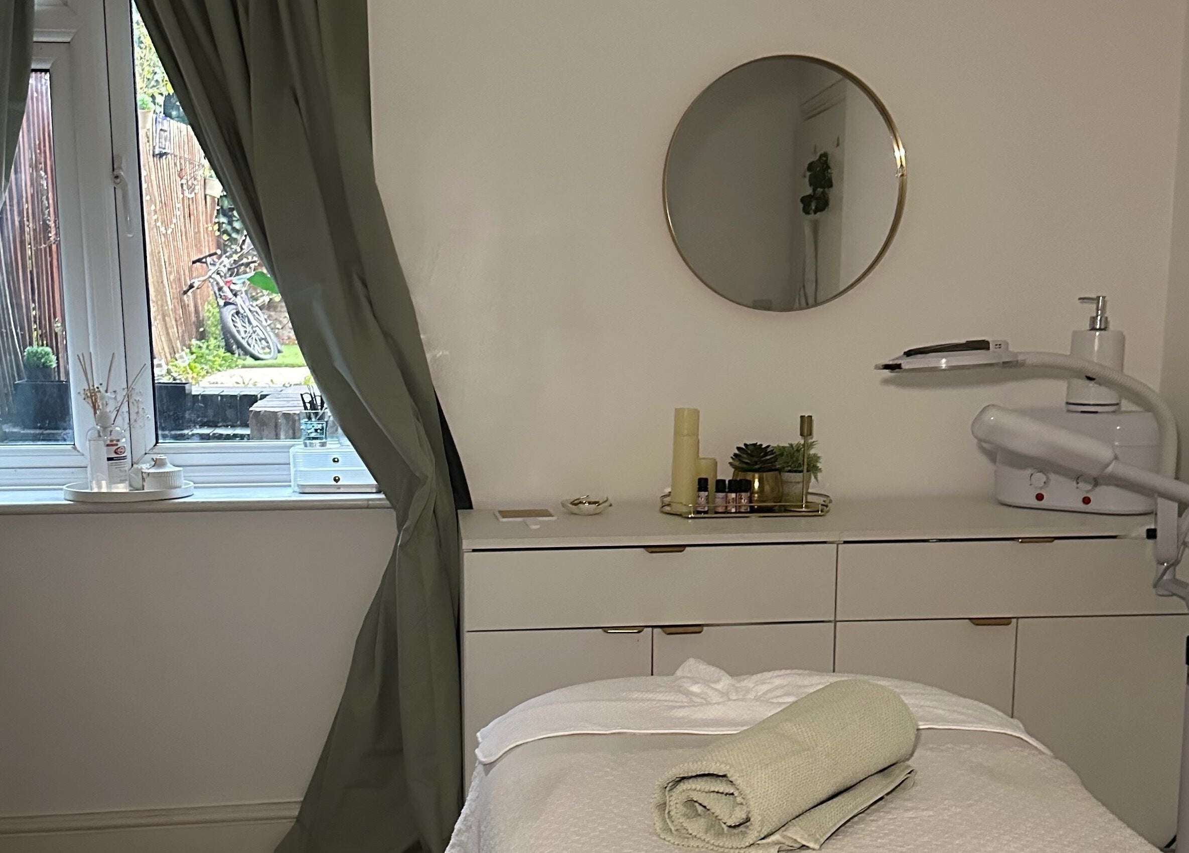 Serene treatment room at Reena’s Touch, London, England, with massage bed and calming decor.