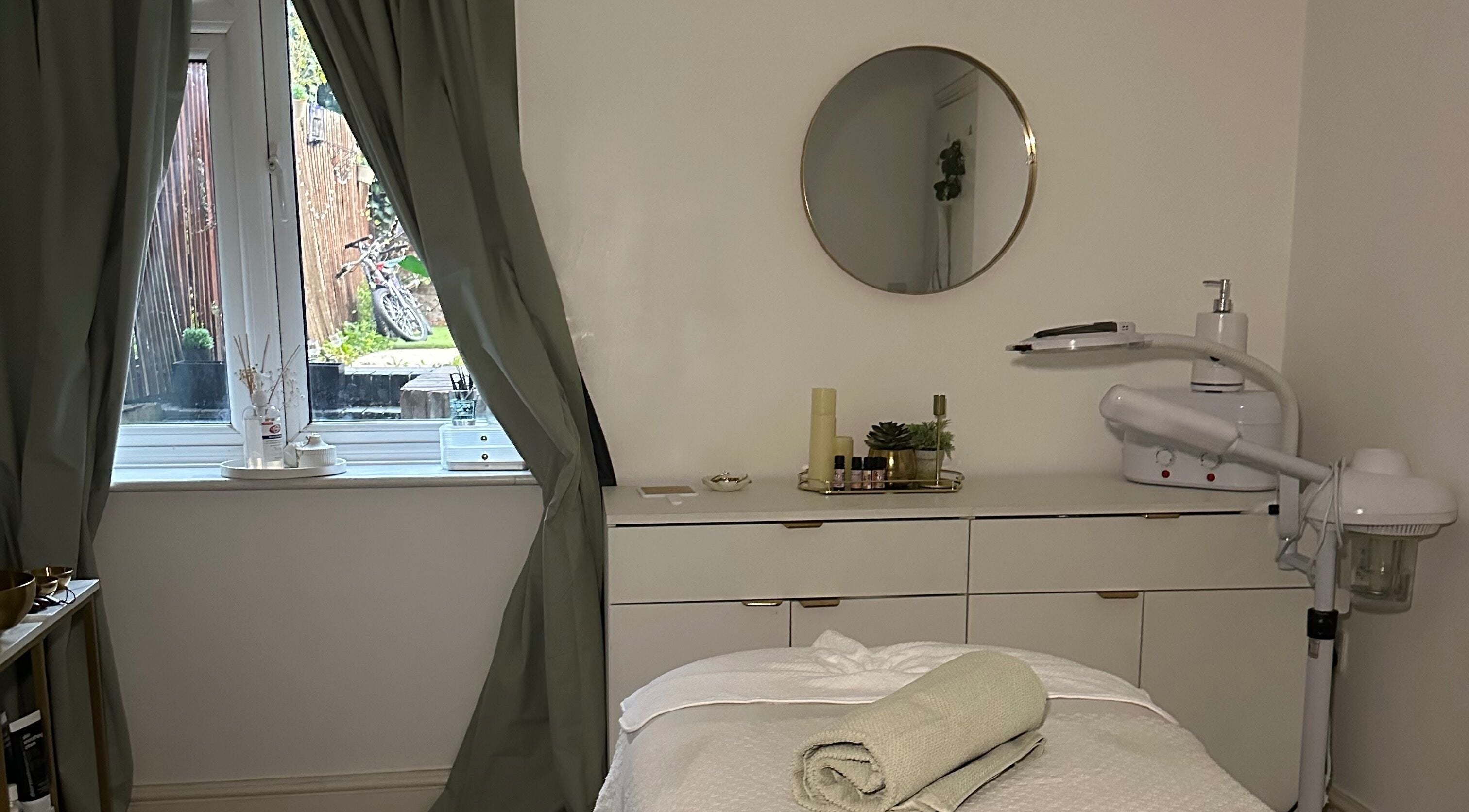 Serene treatment room at Reena’s Touch, London, England, with massage bed and calming decor.