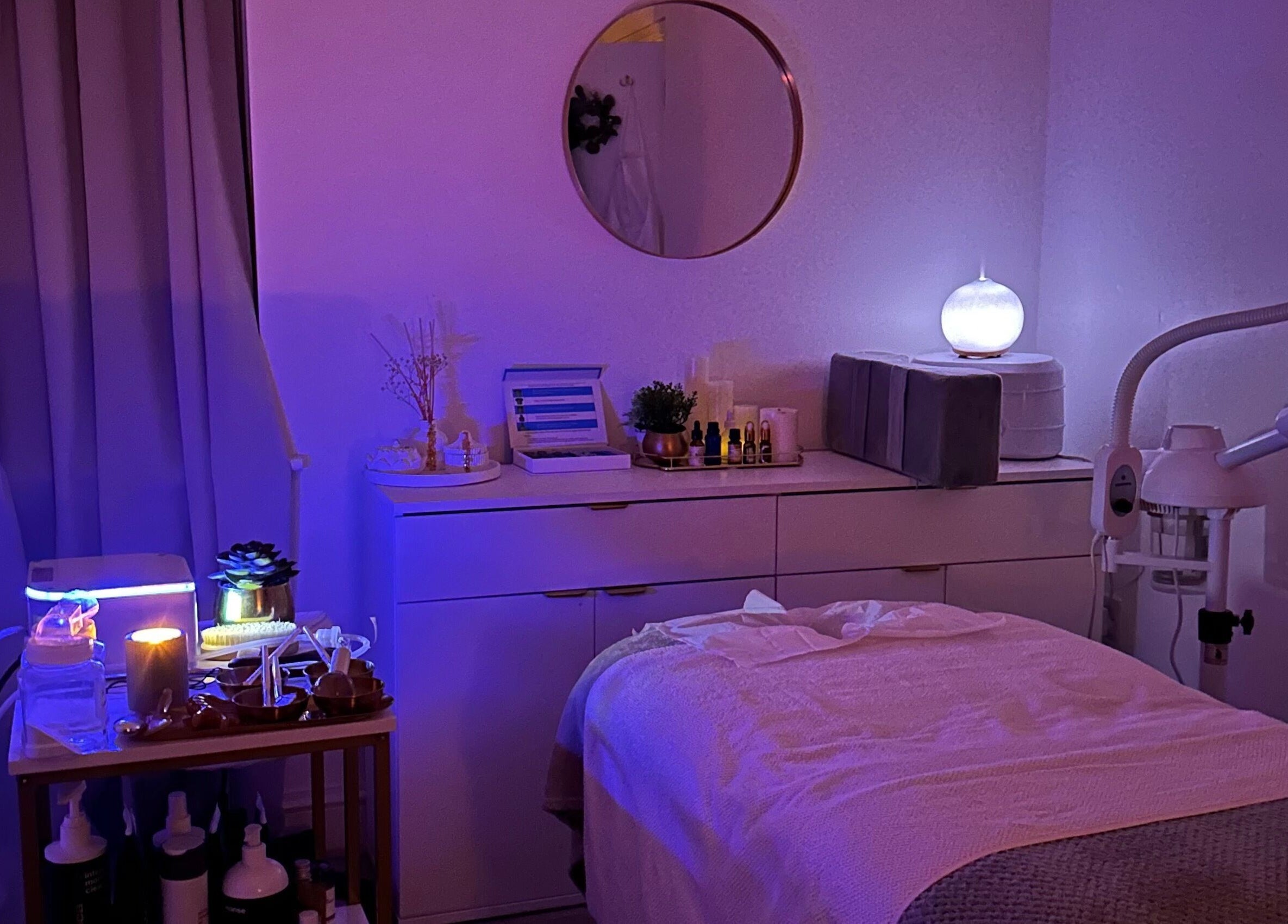 Reena’s Touch spa room with soft lighting, London, England, GB, showcasing a treatment bed and soothing decor.