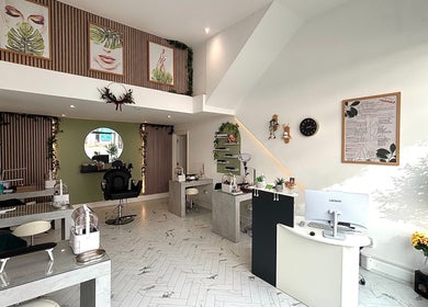 Chic interior of Dua Beauty Studio, Brighton, England, GB with modern design and lush greenery.