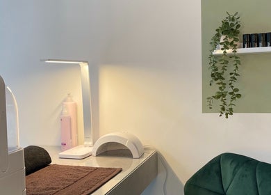 Cozy treatment area at Dua Beauty Studio, Brighton, England, GB. Features a lamp, chair, and beauty tools.