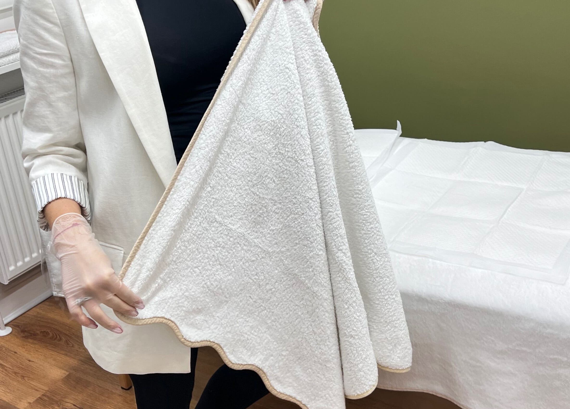 Massage table with a neatly folded towel at M Sculpt, Southampton, England, GB. Ideal for relaxation services.