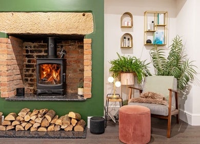 Inviting fireplace lounge at Verve, Matlock, England, GB with lush plants and cozy seating.