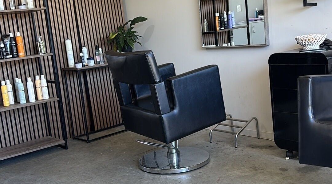 Modern salon chair at Rah, Hastings, Hawke's Bay, NZ, surrounded by stylish shelves and beauty products.