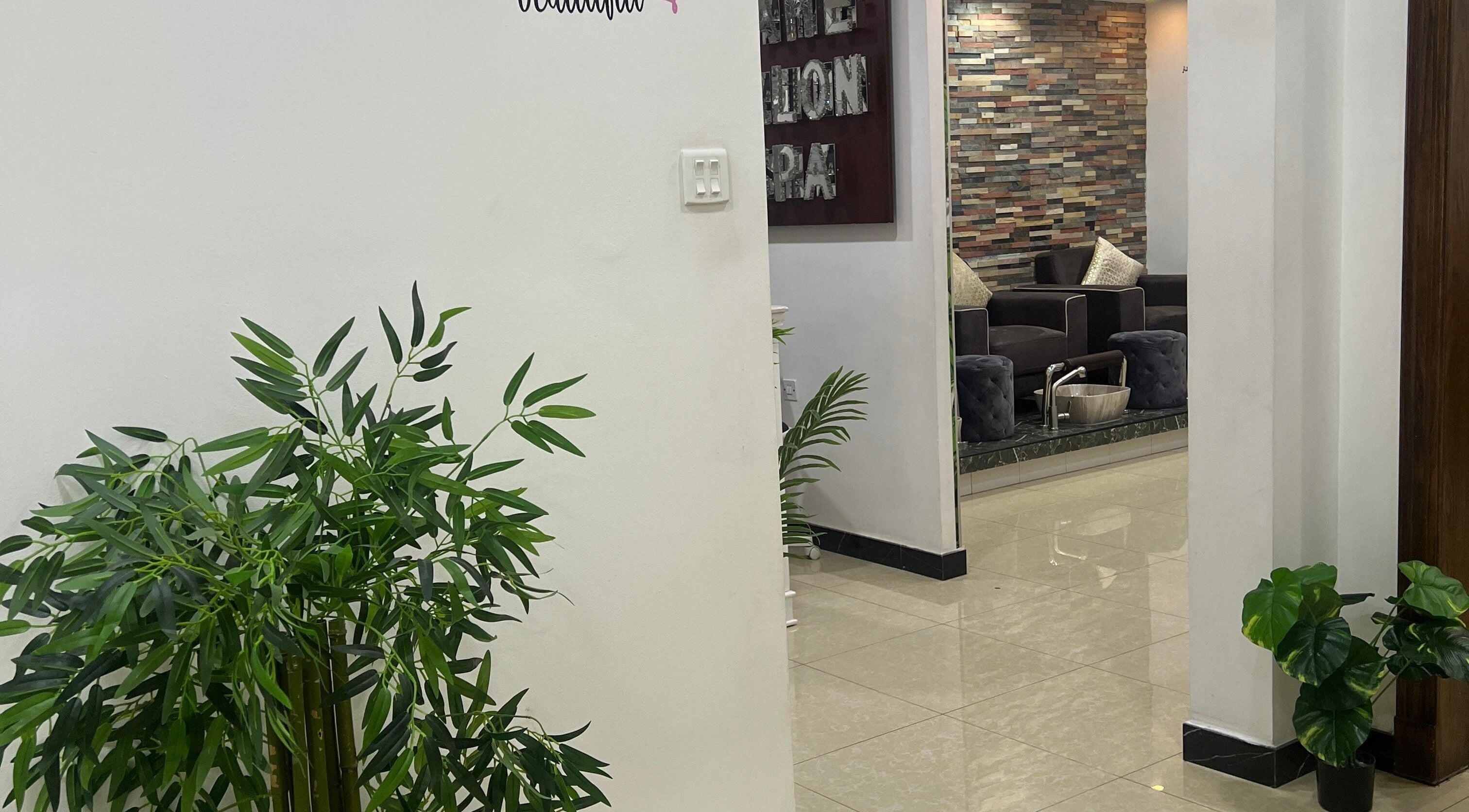 Inviting interior of Dame Salon & Spa in Muharraq Governorate, BH with lush greenery and comfortable seating.