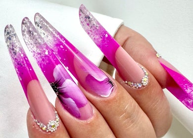 Unghie glamour fucsia con dettagli floreali e glitter presso Daniela De Furia Nails Specialist, Casalgrande, Emilia-Romagna, IT.
