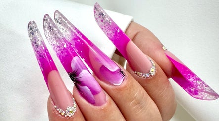 Unghie glamour fucsia con dettagli floreali e glitter presso Daniela De Furia Nails Specialist, Casalgrande, Emilia-Romagna, IT.
