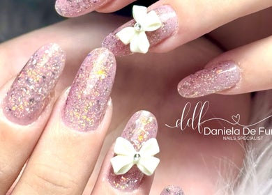 Unghie decorate con glitter e fiocco bianco da Daniela De Furia Nails Specialist, Casalgrande, Emilia-Romagna, IT.
