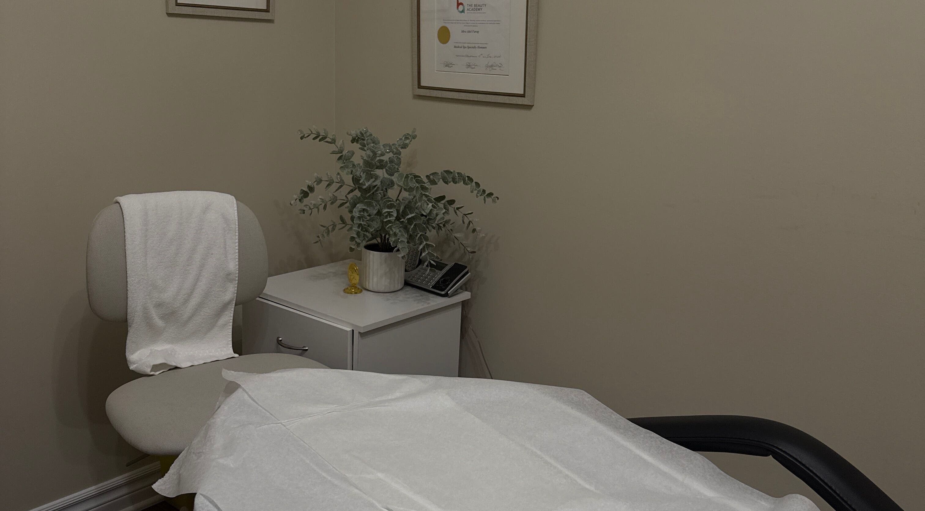 Cozy treatment room at Mira beauty in Ottawa, Ontario, CA, featuring a chair, greenery, and relaxing ambiance.