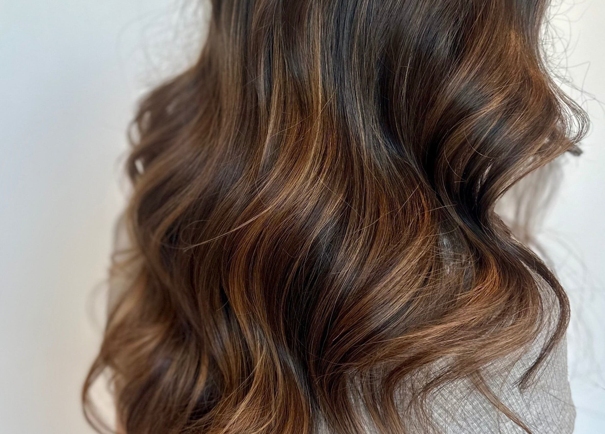 Boucles brunes impeccables à Studio Mode, Montréal, Québec, CA, mettant en valeur des tons riches.