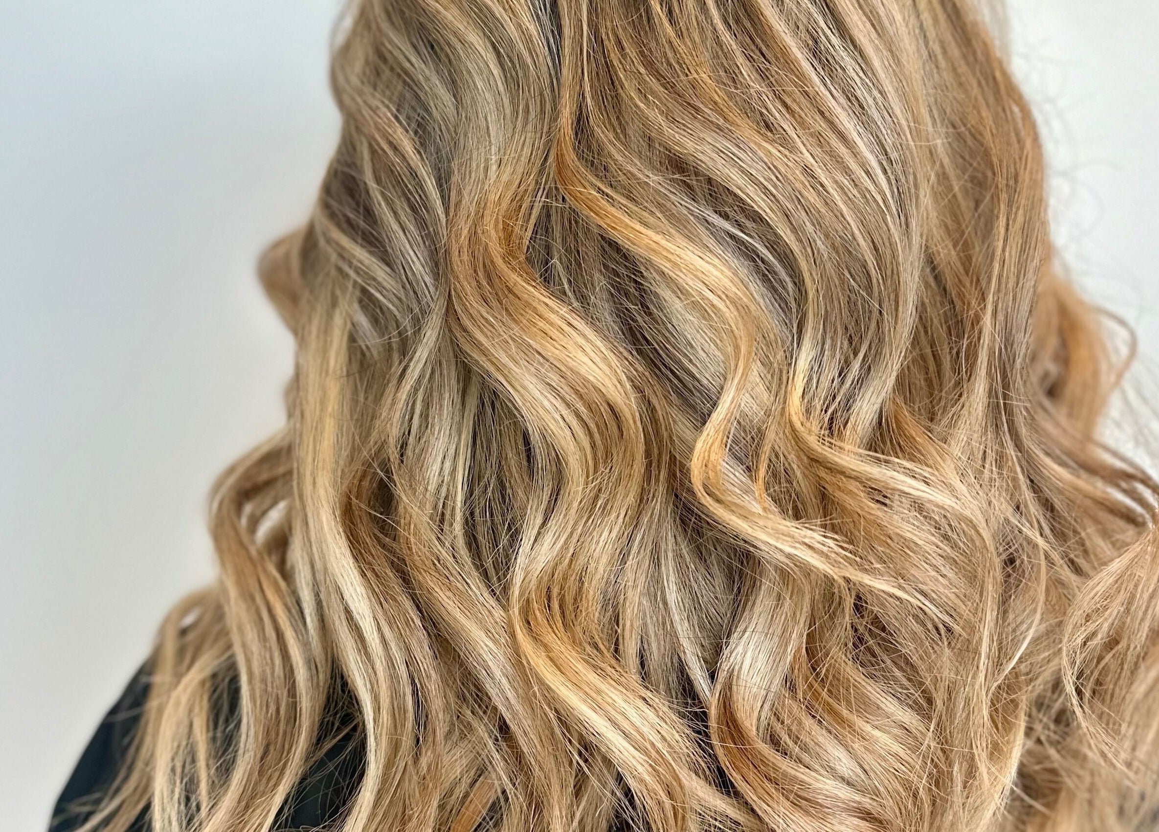 Vagues dorées chez Studio Mode à Montréal, Québec, CA, reflétant des cheveux ondulés professionnels.