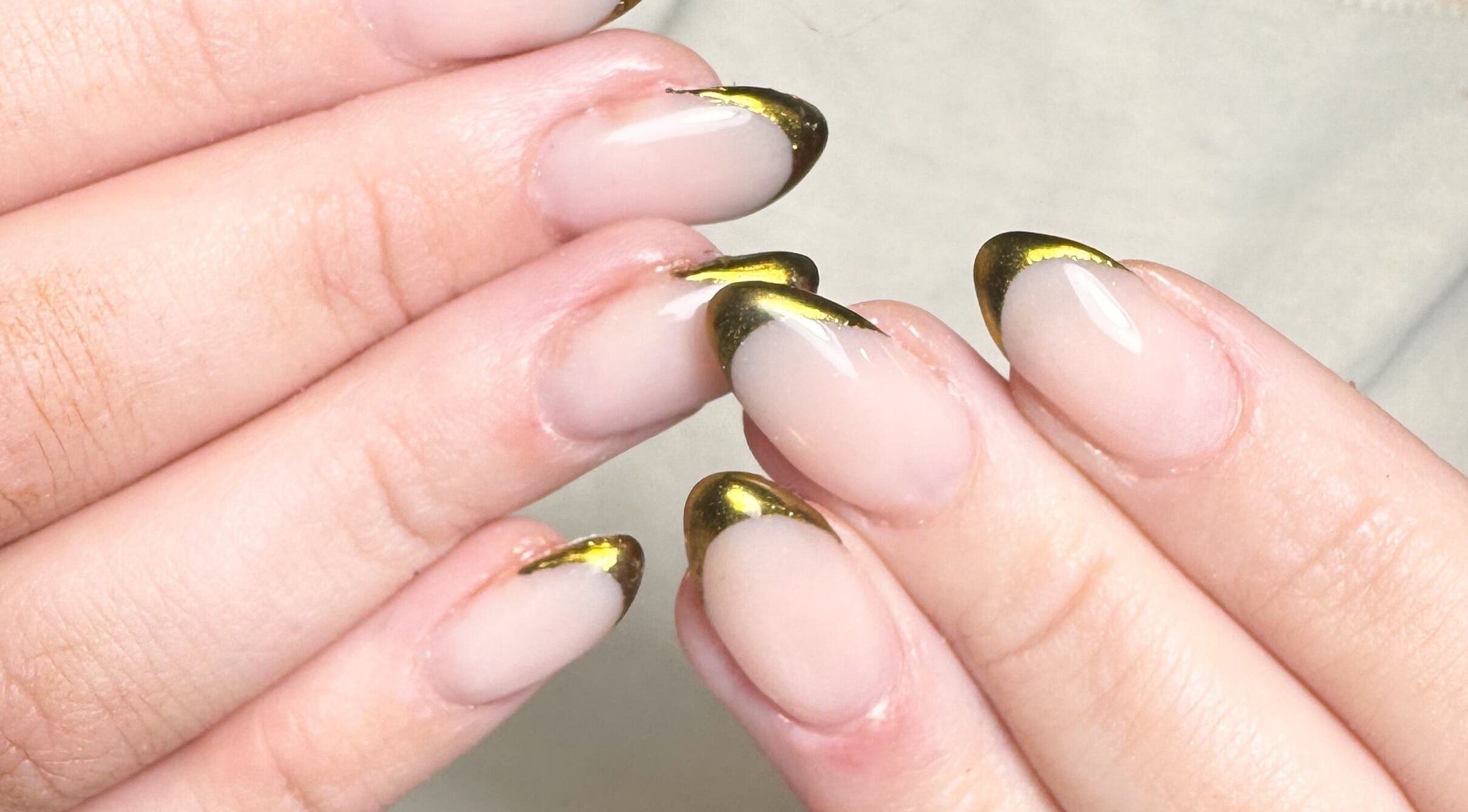 Elegant gold-tipped manicure at Studio Gelle in Standish, England, GB, showcasing professional nail artistry.