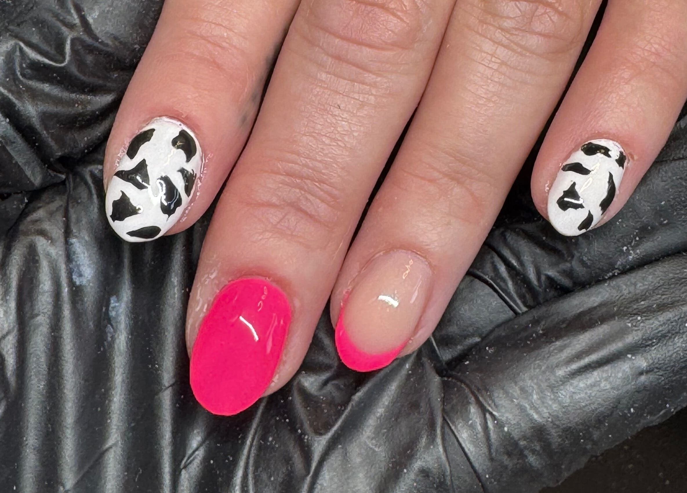 Unique cow print nail art with pink accents at Studio Gelle, Standish, England, GB.