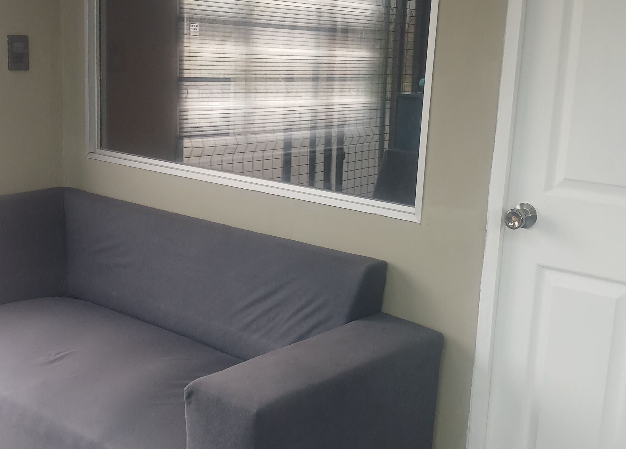 Comfortable grey sofa in Zsquared Hair And Beauty Salon's cozy waiting area, Phoenix, Kwazulu-natal, ZA.