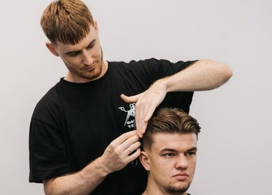 Barber at MAD BARBERS Jelgava, LV expertly trims a client's hair.