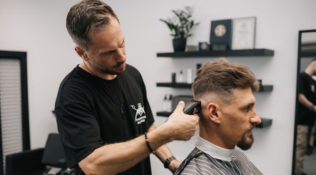 Barber expertly trims hair at MAD BARBERS, Jelgava, LV, showcasing professional grooming services.