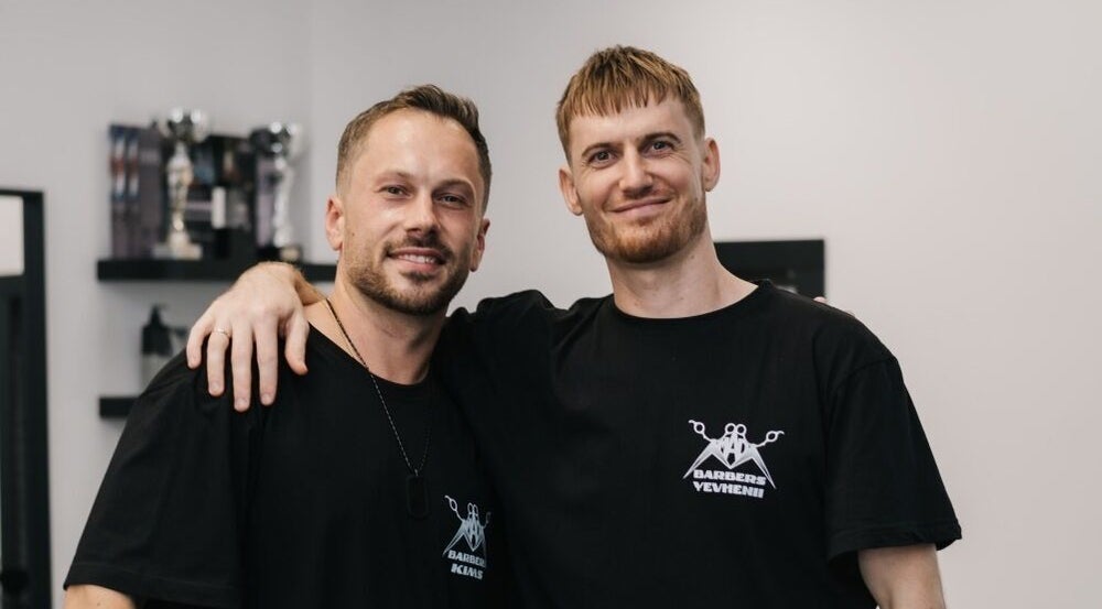 Two friendly barbers at MAD BARBERS, Jelgava, LV showcasing their stylish salon.