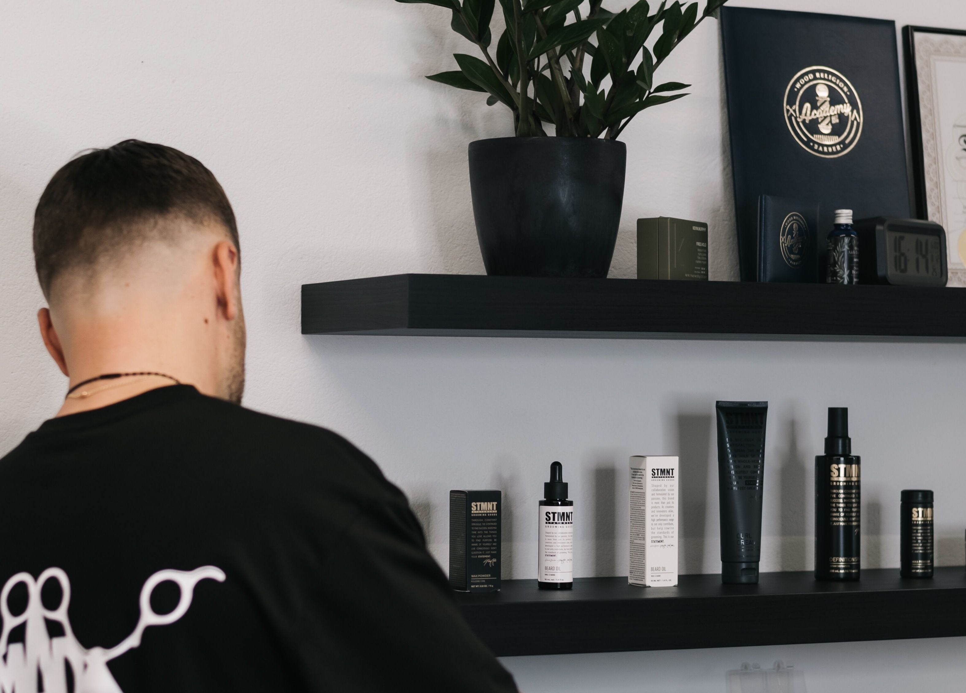 Back view of a person with shelves of grooming products at MAD BARBERS, Jelgava, LV.
