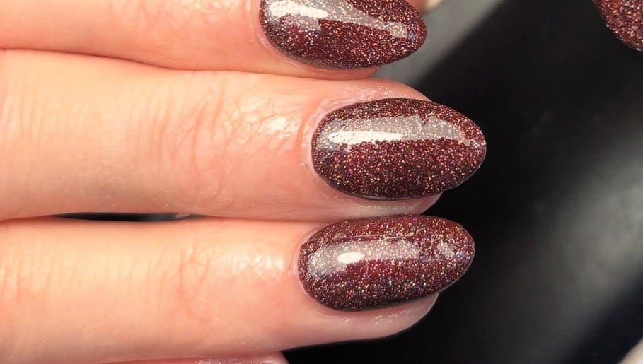 Elegant glittery manicure at Juicy Beauty, Gateshead, England, GB showcasing maroon sparkly nails.
