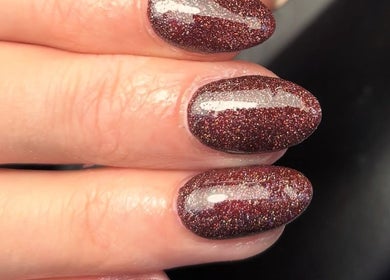 Elegant glittery manicure at Juicy Beauty, Gateshead, England, GB showcasing maroon sparkly nails.