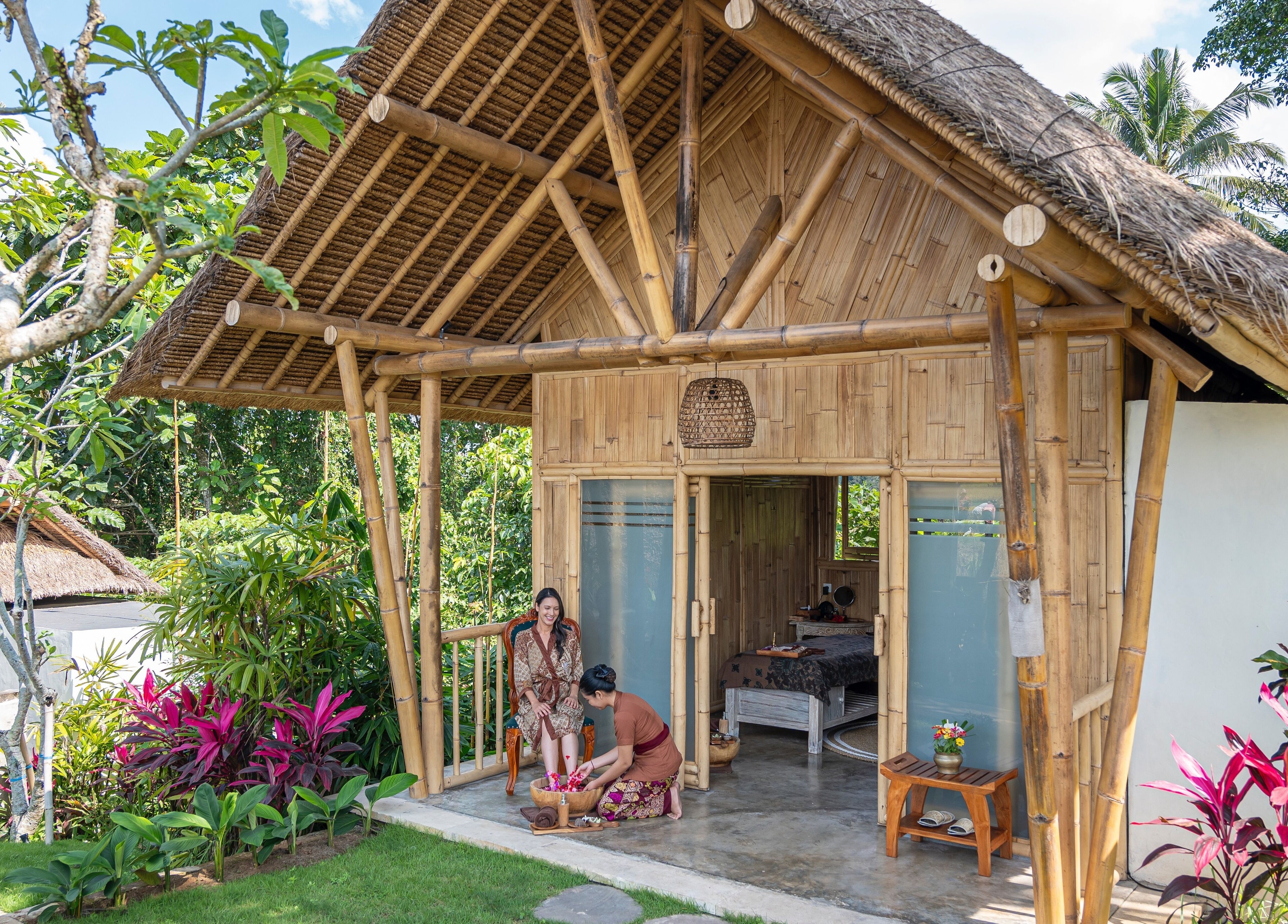 Peaceful bamboo spa hut at Visesa Spa, Bali, Bali, ID, surrounded by lush greenery and blooming flowers.